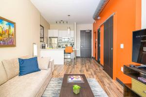 a living room with a couch and an orange wall at Private Downtown Apartment With City View in Raleigh