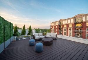 a rooftop patio with couches and tables on a building at Private Downtown Apartment With City View in Raleigh