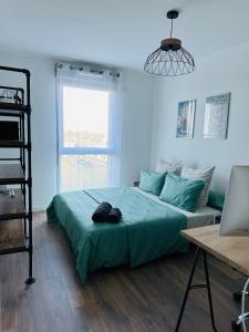 1 dormitorio con 1 cama y escritorio con ordenador portátil en Chambre privative et confortable, en Angers