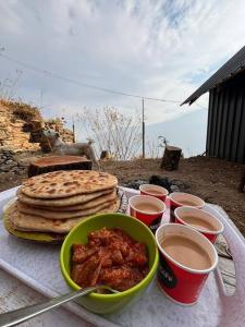 a table with a plate of food with pancakes and sauce at Woodstone Farmstay in Sainj