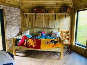 a bedroom with a bed in a wooden cabin at Hagrids Hut - Off grid Cabin - no electricity or running water in Munlochy
