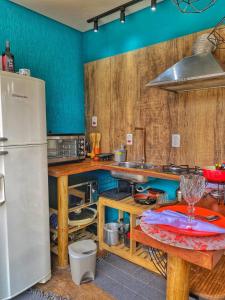 a kitchen with a refrigerator and a table at C-house in Ubatuba