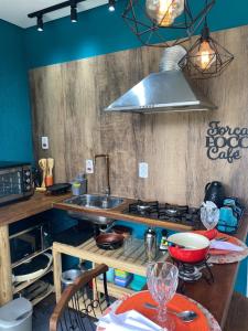a kitchen with a sink and a stove top oven at C-house in Ubatuba