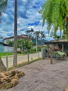 a park with a bench and palm trees and a building at C-house in Ubatuba