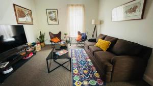 a living room with a couch and a tv at Shotgun House in Silverton