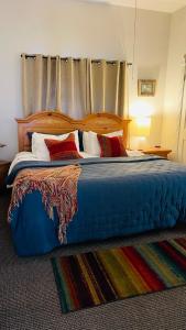 sypialnia z dużym niebieskim łóżkiem z poduszkami w obiekcie Shotgun House w mieście Silverton