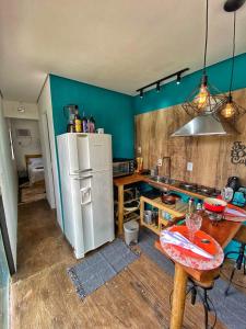 uma cozinha com um frigorífico branco e uma mesa em C-house em Ubatuba