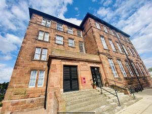 a brick building with stairs in front of it at North Kelvin Guest House in Glasgow