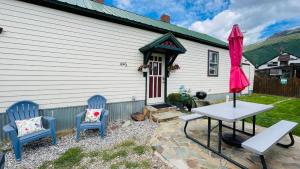 a patio with two chairs and a table and an umbrella at Shotgun House in Silverton