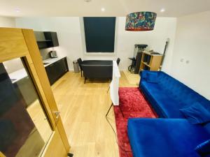 uma sala de estar com um sofá azul e uma mesa em North Kelvin Guest House em Glasgow