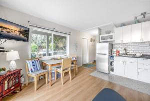 a kitchen with a table and chairs and a refrigerator at The Lakeside Cabin with wide outside space #105 in West Kelowna