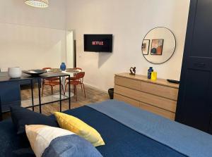 una camera da letto con un letto, un tavolo e uno specchio di Etna charme apartment a Catania