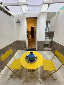 un tavolo giallo e sedie in una stanza di Etna charme apartment a Catania