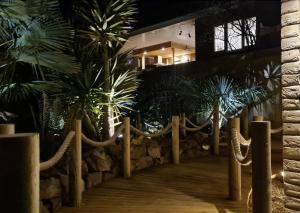 a fence with palm trees in front of a building at Blue Cedars Minehead in Minehead