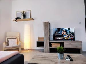 a living room with a flat screen tv on a table at LA88 Sweet Home in San Ġwann