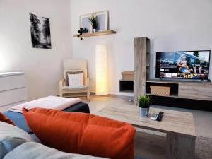 a living room with a couch and a tv at LA88 Sweet Home in San Ġwann