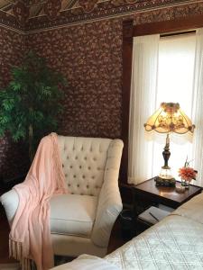 a living room with a white couch and a lamp at The Nauvoo Grand Bed & Breakfast in Nauvoo
