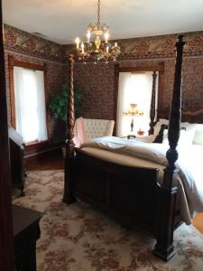 a bedroom with a bed and a chandelier at The Nauvoo Grand Bed & Breakfast in Nauvoo