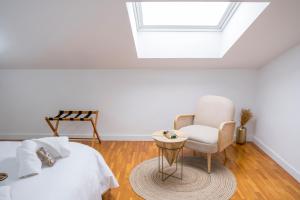 a bedroom with a bed and a chair and a skylight at El Deseo del Carmen in El Burgo de Osma +42 photos
