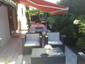 a patio with two chairs and a table and an umbrella at Chambres d'Hotes des Ecureuils in Lanton