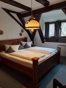 a bedroom with a large bed with a chandelier at Altfraenkische Weinstube in Rothenburg ob der Tauber