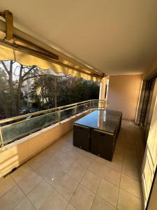 balkon ze stołem i dużym oknem w obiekcie Résidence Californie Cannes w Cannes