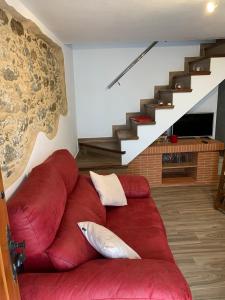 a red couch in a living room with stairs at El callejón in Benarrabá +27 photos