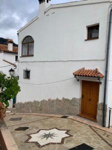 a white building with a star painted on the side of it at El callejón in Benarrabá