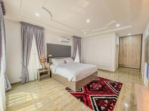 a bedroom with a white bed and a red rug at Emma's Court in Lagos