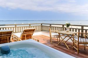 a bath tub on a deck with a table and chairs at Les Vagues Hotel & Spa in Arcachon