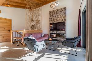 a living room with a couch and chairs and a fireplace at Chalet Charlotte in Niedernsill