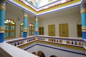 una sinagoga vacía con columnas y ventanas azules en THE CHETTINAD HERITAGE, en Kānādukāttān