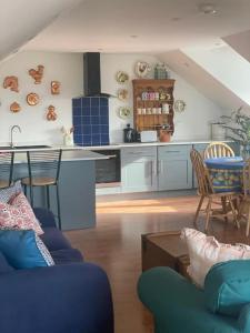 uma cozinha e uma sala de estar com mesa e cadeiras em Countryside cottage with private garden & hot tub em Lifton