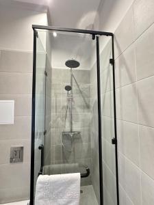 a shower with a glass door in a bathroom at Five Hotel in Prigorodnyy