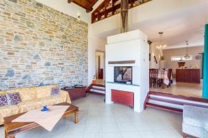 a living room with a couch and a brick wall at Villa Anatoli in Skopelos Town
