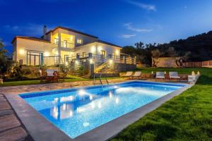 a villa with a swimming pool in front of a house at Villa Anatoli in Skopelos Town
