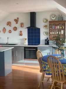 a kitchen with a table and chairs and a stove at Countryside cottage with private garden & hot tub in Lifton
