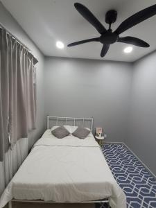 1 dormitorio con 1 cama y ventilador de techo en JRC Homestay Kerteh, en Kampong Kemaman
