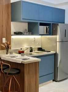 a kitchen with blue cabinets and a refrigerator at Flat Encantador Allianz Park 708 in Sao Paulo