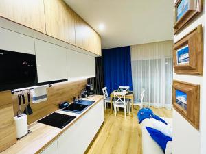 a kitchen with white cabinets and a table in a room at Sunset Resort Apartament Marco Marina in Grzybowo +15 photos
