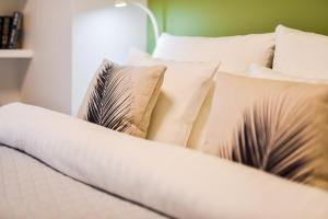 a bed with white pillows on top of it at Apartamenty Tespis - Francuska Atal Park PREMIUM in Katowice