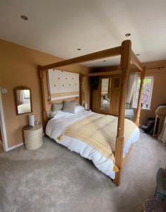 a bedroom with a large bed with a wooden frame at Peak District Home from Home! in Grindleford Bridge