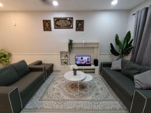 a living room with two couches and a table at JRC Homestay Kerteh in Kampung Sekuang