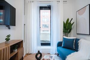 ein Wohnzimmer mit einem blauen Stuhl und einem Fenster in der Unterkunft 74-4A 2BR 2baths in Prime Upper West Side w d GYM in New York