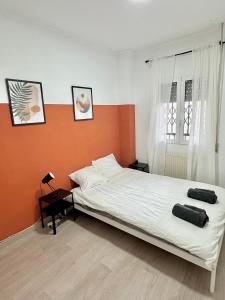 a bedroom with a bed with an orange wall at Casa Únic - Moderno Alojamiento en Ruzafa in Valencia