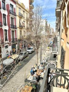 a group of people sitting at tables on a city street at Casa Únic - Moderno Alojamiento en Ruzafa in Valencia