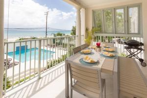 Una mesa en un balcón con vista al mar. en 102 Lighthouse Bay Barbados, en Christ Church