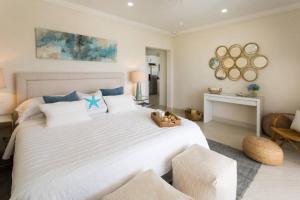 Un dormitorio con una gran cama blanca en una habitación. en 102 Lighthouse Bay Barbados, en Christ Church