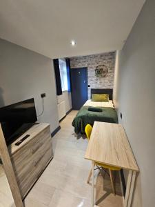 1 dormitorio con cama, escritorio y mesa en Tudor Road House, en Leicester