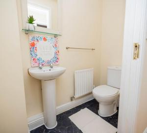 uma casa de banho com um lavatório e um WC em Charming 4-bedroom home in Corby em Great Oakley